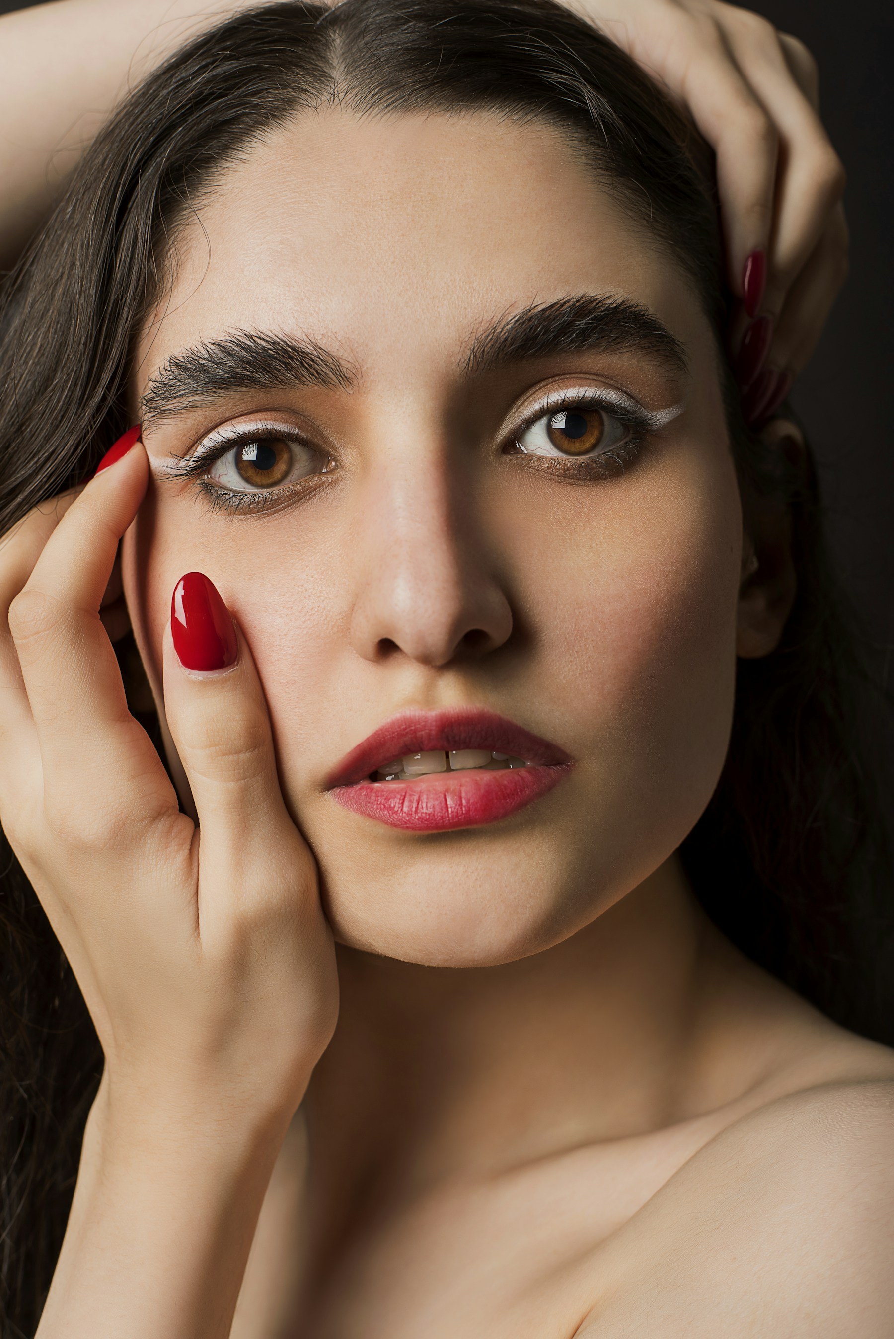 Beauty portrait showcasing a glossy red manicure